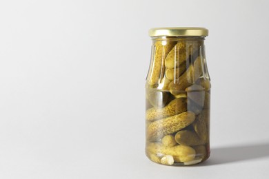 Photo of Pickled cucumbers in jar on light background. Space for text