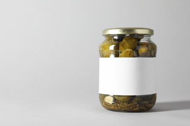 Photo of Pickled cucumbers in jar on light background. Space for text