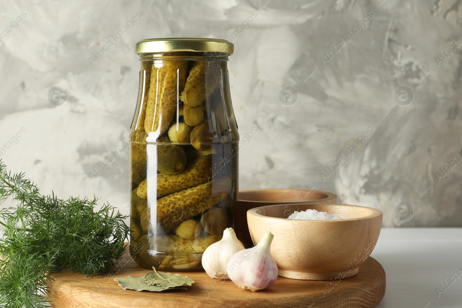 Photo of Pickled cucumbers in jar and spices on white table