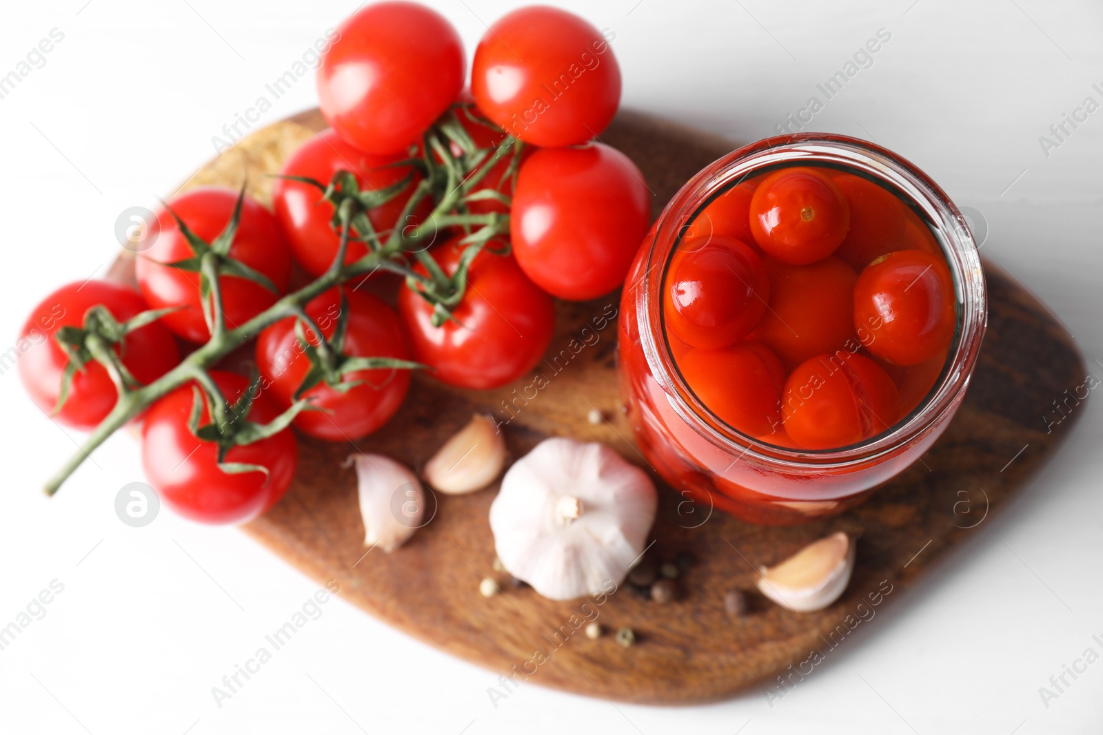 Photo of Tasty pickled tomatoes in jar, fresh vegetables and spices on white table, top view