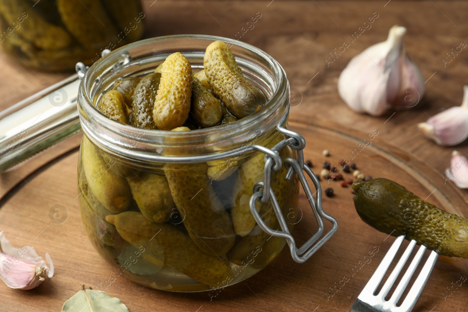 Photo of Pickled cucumbers in open jar on wooden table, closeup