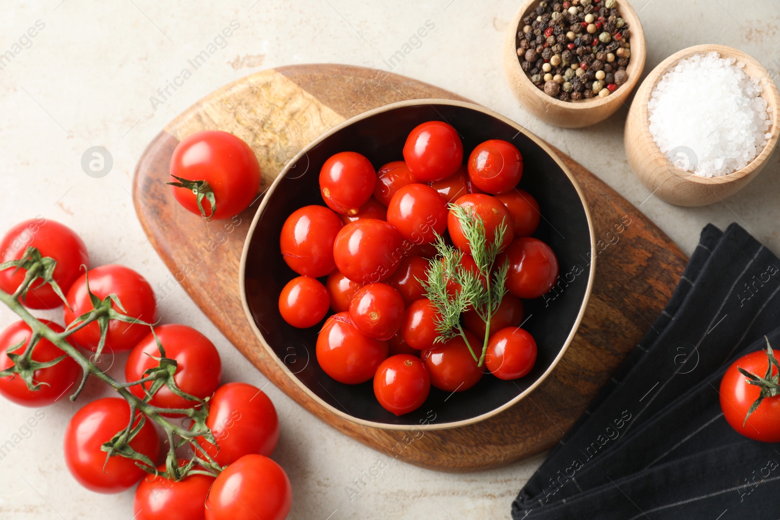 Photo of Tasty pickled tomatoes in bowl, spices and fresh vegetables on light grey table, top view