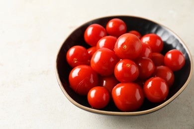 Tasty pickled tomatoes in bowl on light grey table