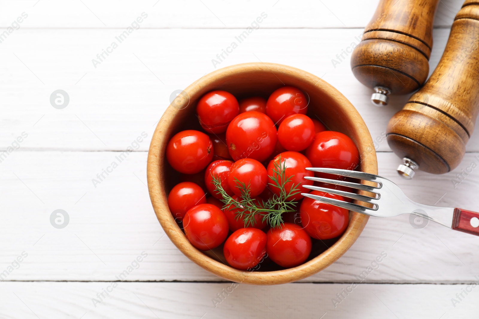 Photo of Tasty pickled tomatoes, dill and fork on white wooden table, top view. Space for text