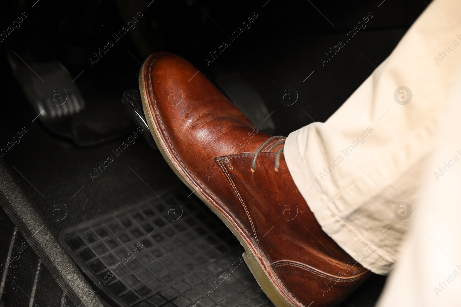 Photo of Man pushing on pedal of car brake, closeup