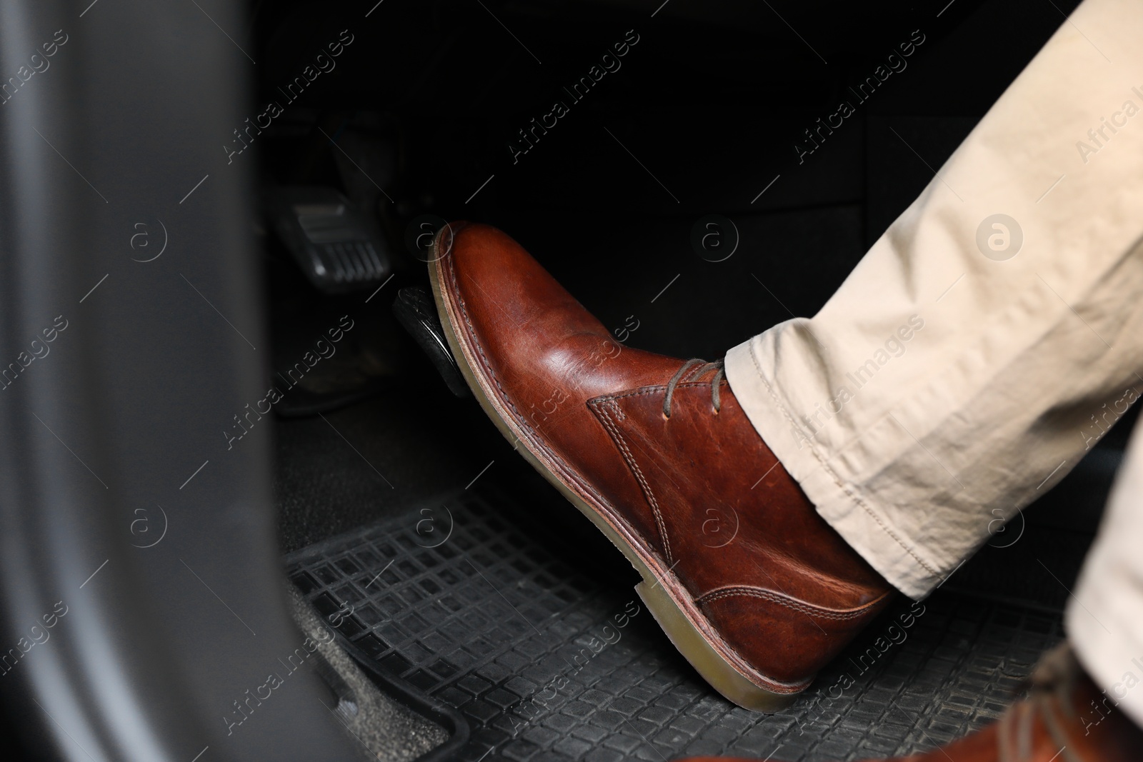 Photo of Man pushing on pedal of car brake, closeup