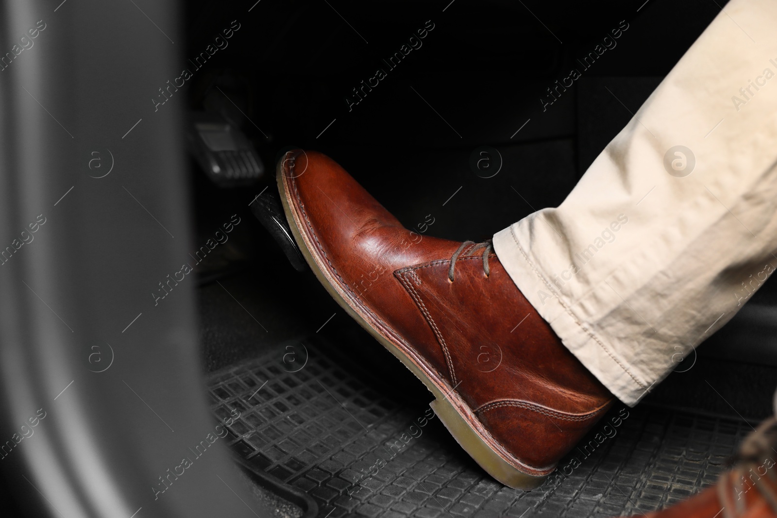 Photo of Man pushing on pedal of car brake, closeup