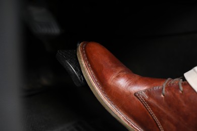 Photo of Man pushing on pedal of car brake, closeup