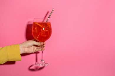 Photo of Woman with glass of refreshing cocktail on pink background, closeup. Space for text