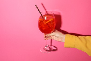 Photo of Woman with glass of refreshing cocktail on pink background, closeup. Space for text