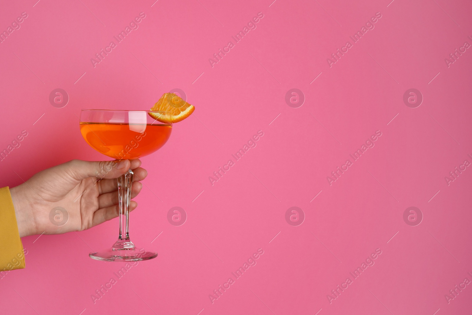 Photo of Woman with glass of refreshing cocktail on pink background, closeup. Space for text