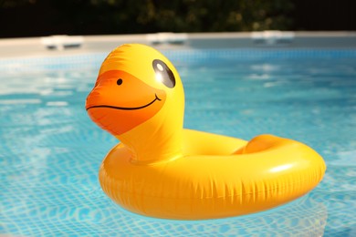 Inflatable duck shaped ring on water in above ground swimming pool outdoors