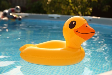 Photo of Inflatable duck shaped ring on water in above ground swimming pool outdoors