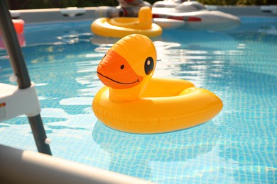 Photo of Inflatable duck shaped ring on water in above ground swimming pool outdoors