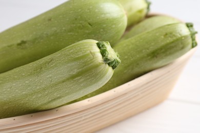 Photo of Fresh ripe zucchinis on white table, closeup