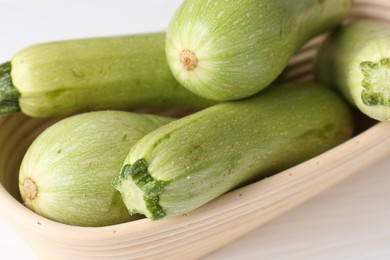 Photo of Fresh ripe zucchinis on white table, closeup