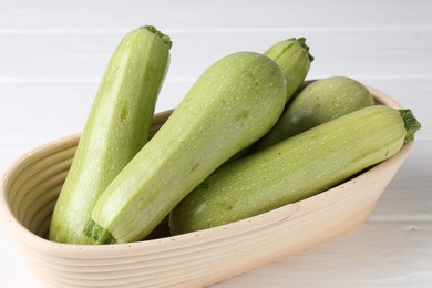 Photo of Fresh ripe zucchinis on white wooden table, closeup