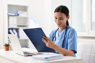 Photo of Smiling nurse working at table in clinic