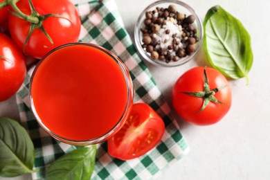 Tasty tomato juice in glass, spices and fresh vegetables on light table, flat lay