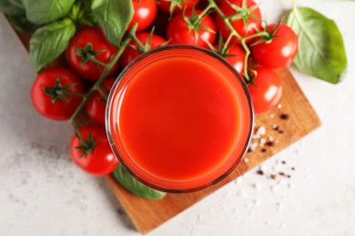 Fresh tomato juice in glass on light table, top view