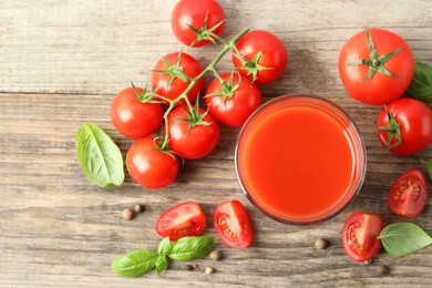 Photo of Tasty tomato juice in glass with fresh vegetables and spices on wooden table, flat lay