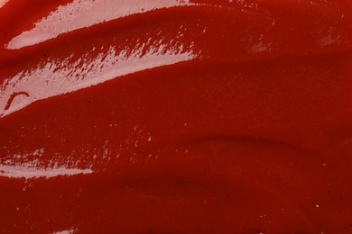 Photo of Texture of tasty ketchup as background, top view. Tomato sauce