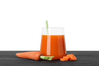 Photo of Fresh carrot juice in glass and vegetables on black wooden table against white background