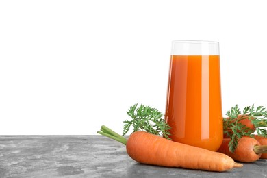 Fresh carrot juice in glass and vegetables on grey textured table against white background. Space for text