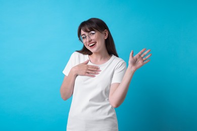 Photo of Happy woman waving on light blue background