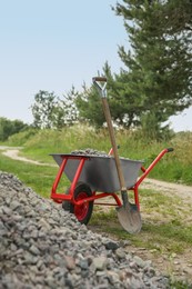 Wheelbarrow full of stones and shovel outdoors