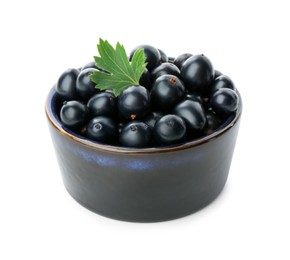 Photo of Bowl of ripe blackcurrants and green leaf isolated on white