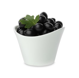 Photo of Bowl of ripe blackcurrants and green leaf isolated on white