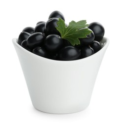 Photo of Bowl of ripe blackcurrants and green leaf isolated on white