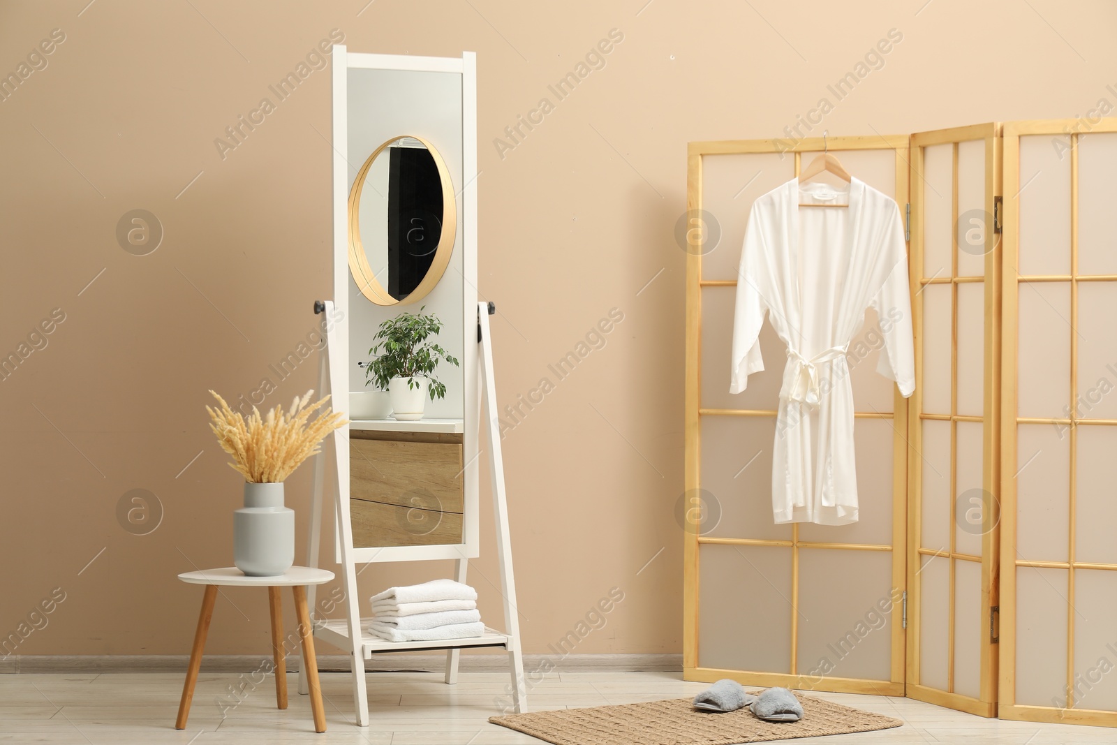 Photo of Large mirror near beige wall in bathroom. Interior design