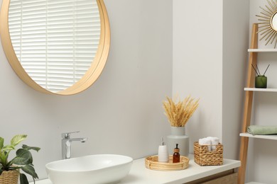 Photo of Round mirror over sink in bathroom. Interior design