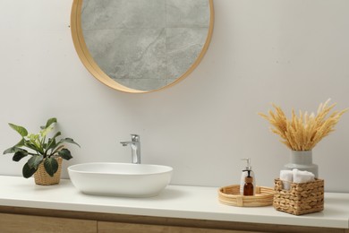 Round mirror over sink in bathroom. Interior design