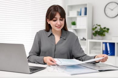 Smiling secretary doing paperwork at table in office