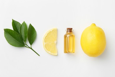 Photo of Bottle of essential oil, lemon and green leaves on white background, flat lay