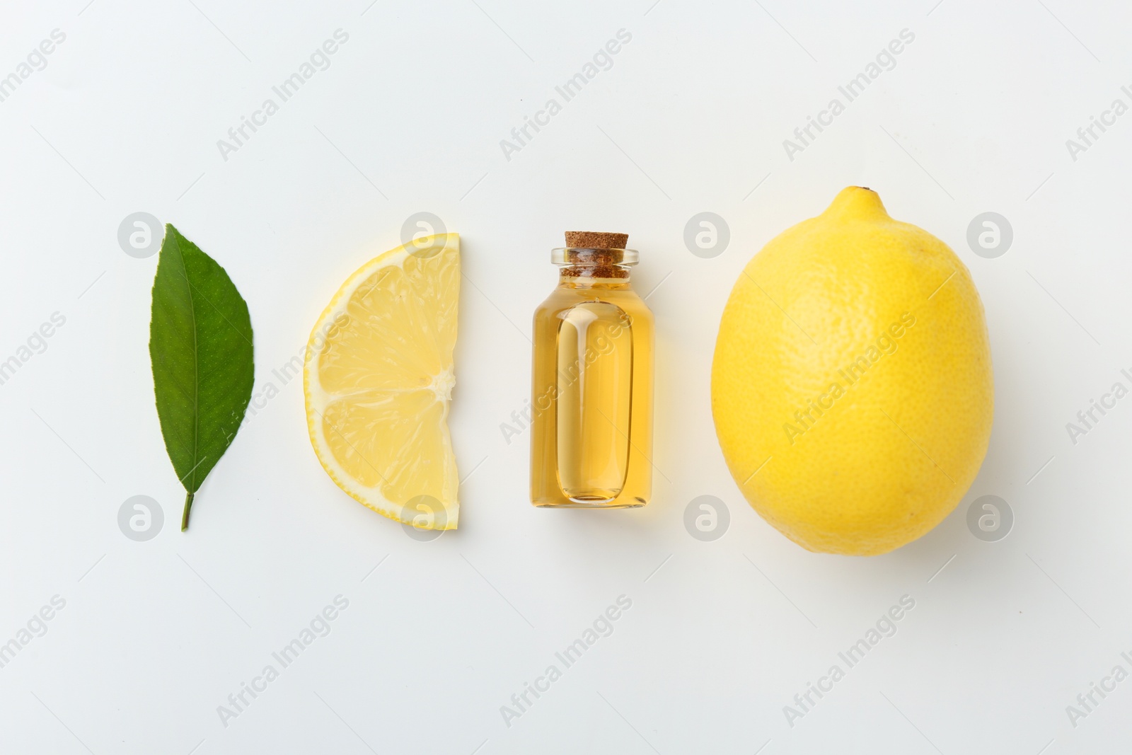 Photo of Bottle of essential oil, lemon and green leaf on white background, flat lay