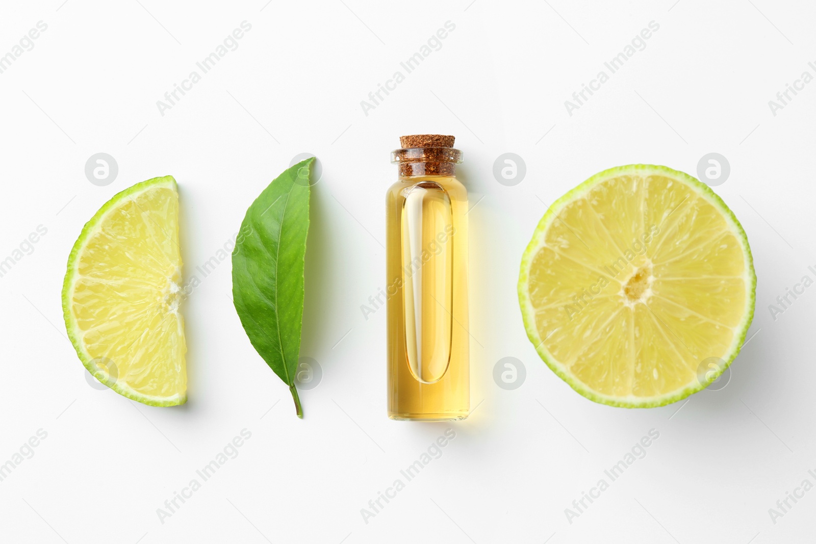 Photo of Bottle of essential oil, lime and green leaf on white background, flat lay