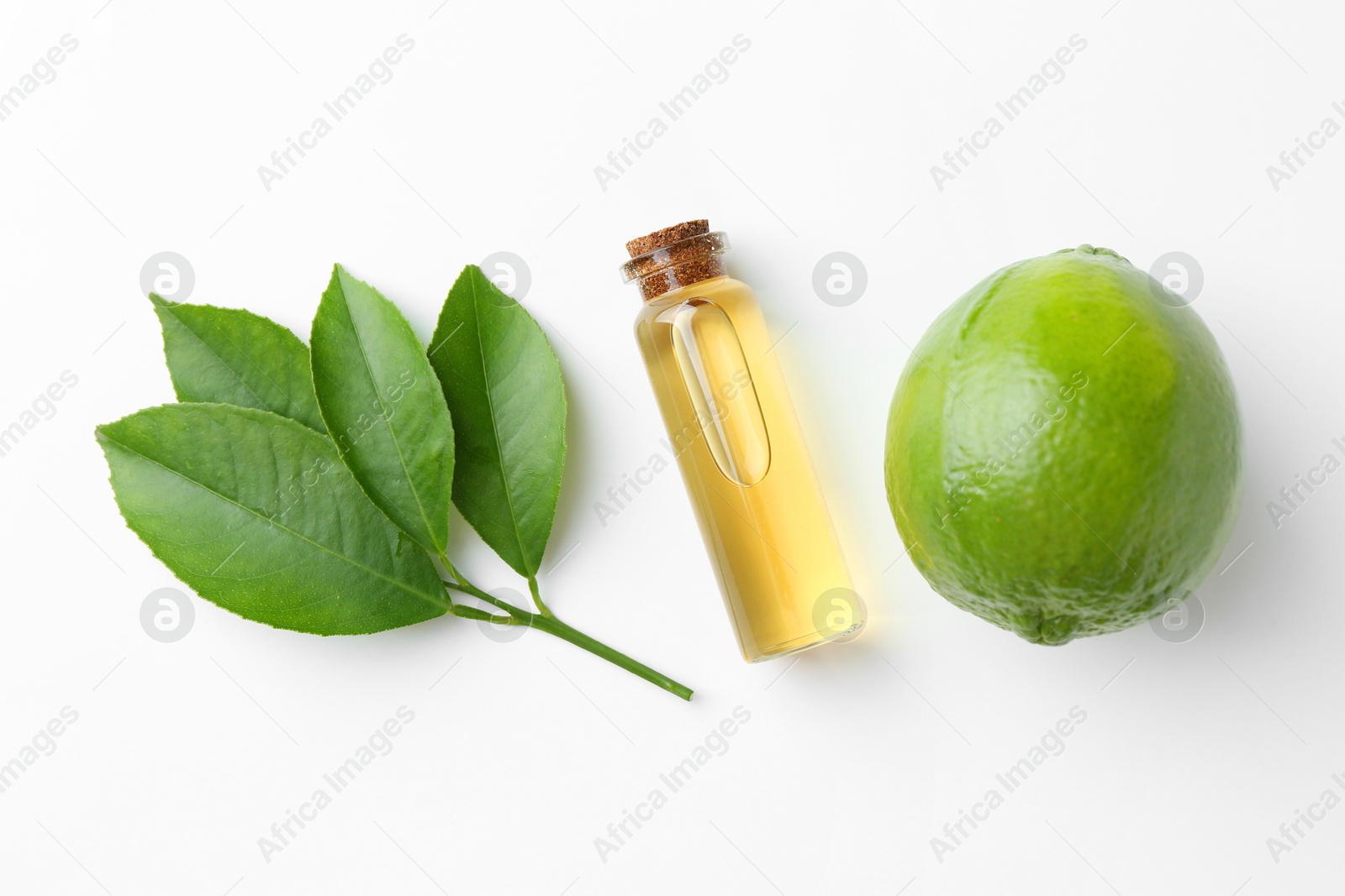 Photo of Bottle of essential oil, lime and green leaves on white background, flat lay