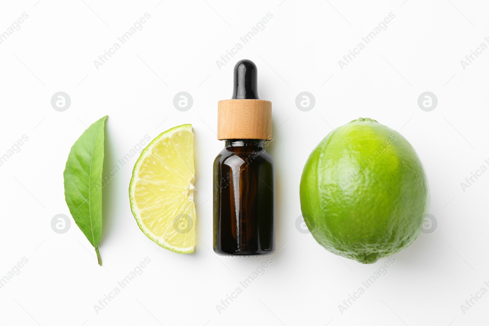 Photo of Bottle of essential oil, lime and green leaf on white background, flat lay