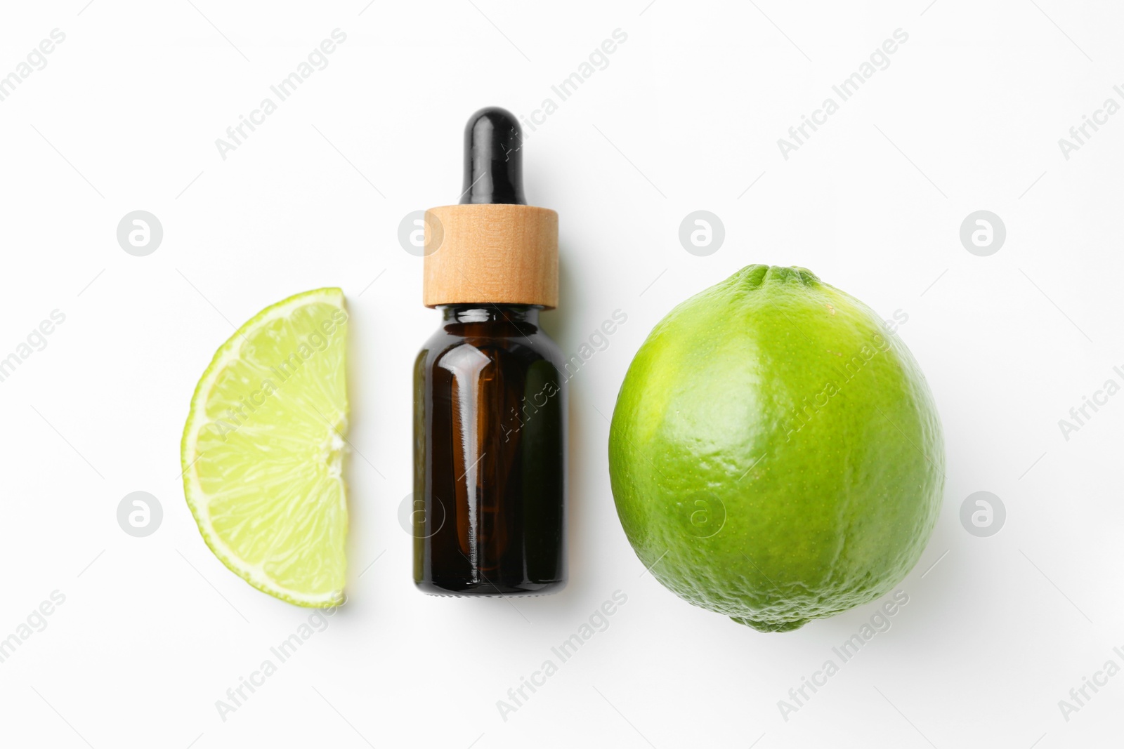 Photo of Bottle of essential oil and lime on white background, flat lay