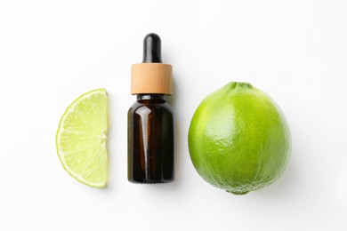 Bottle of essential oil and lime on white background, flat lay