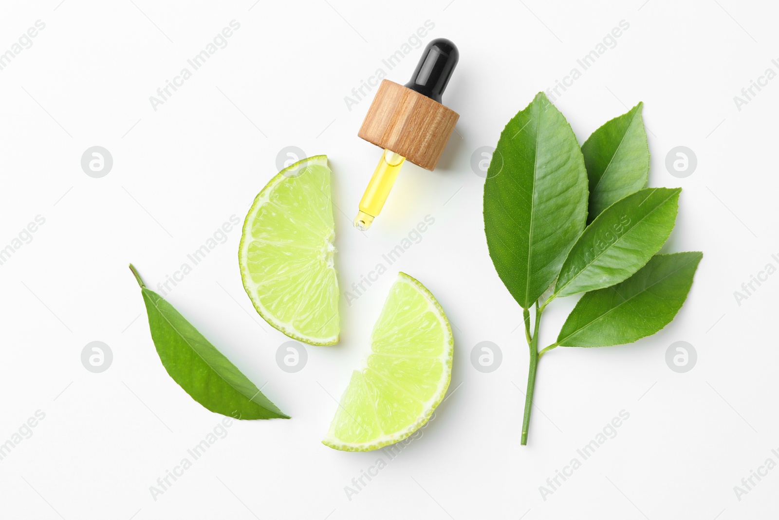 Photo of Pipette of essential oil, lime and green leaves on white background, flat lay