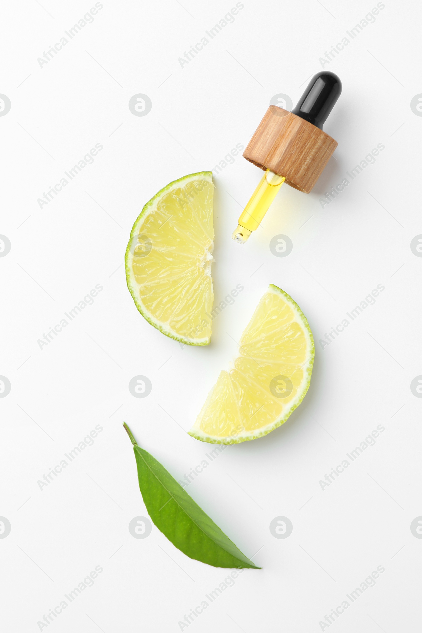 Photo of Pipette of essential oil, lime and green leaf on white background, flat lay