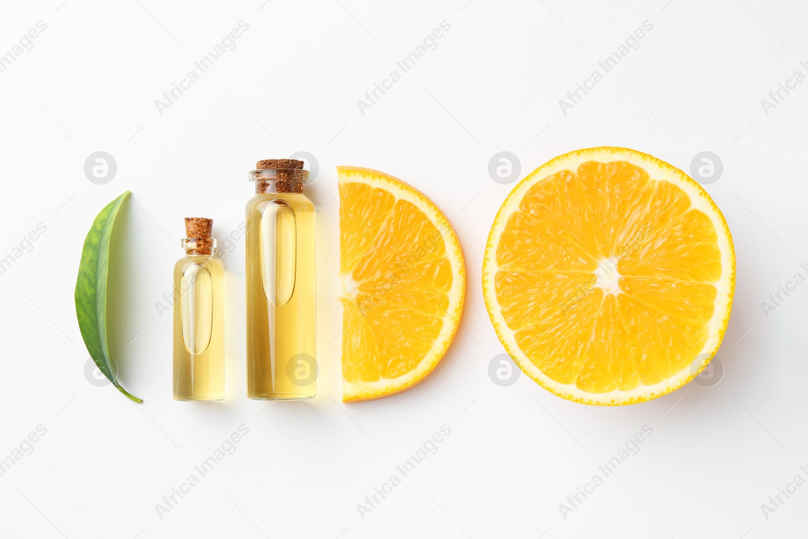 Photo of Bottles of essential oils, orange and green leaf on white background, flat lay