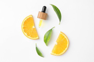 Photo of Dropper of essential oil, orange and green leaves on white background, flat lay