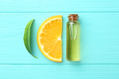 Photo of Bottle of essential oil, orange and green leaf on turquoise wooden table, flat lay