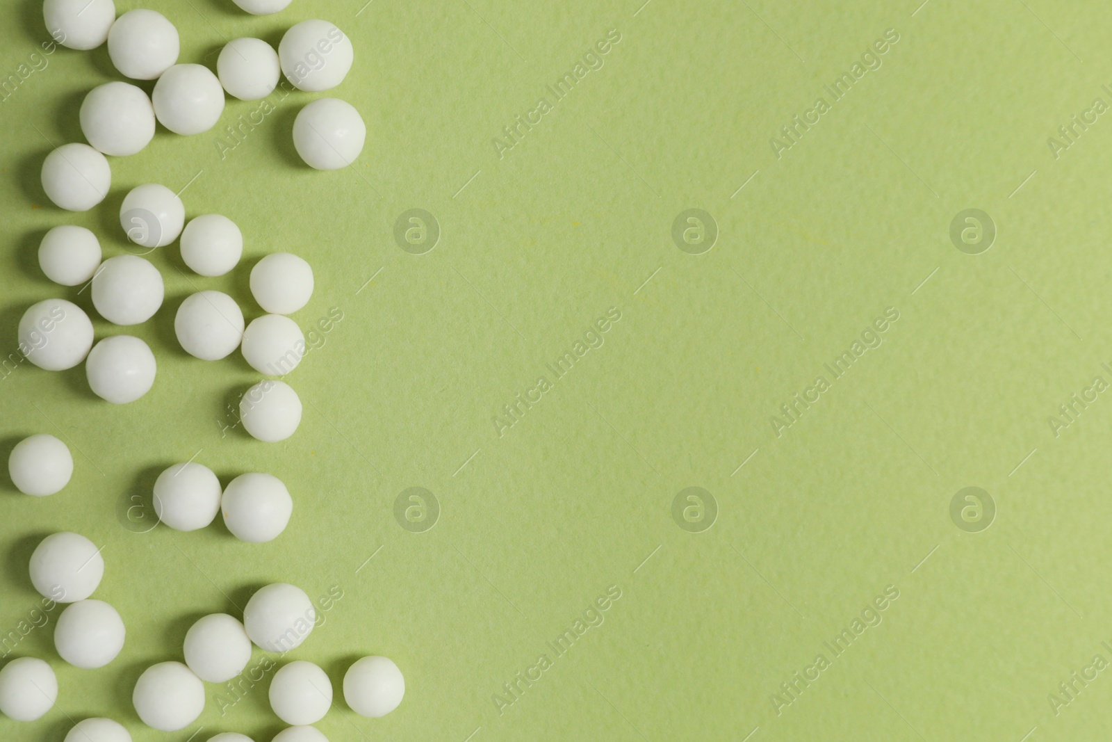 Photo of Homeopathic remedy on light green background, flat lay. Space for text